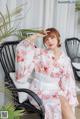 a woman sitting on a chair wearing a pink kimono