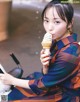 A woman sitting on a bench eating an ice cream cone.