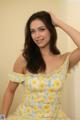 A woman in a yellow dress posing for a picture.