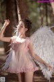 A woman dressed as an angel in a pink dress.