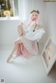 A woman in a wedding dress sitting on a window sill.