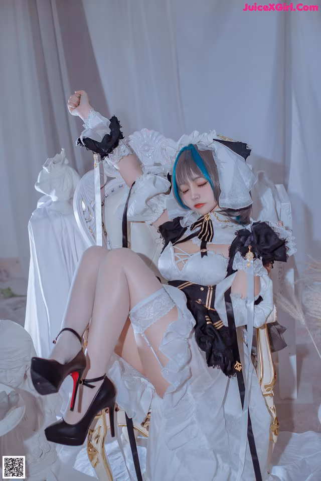 A woman in a white dress sitting on a white chair.