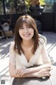 A woman sitting at a table smiling at the camera.