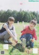 A couple of young women kneeling down in a field.