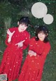 Two young women in red dresses standing in the snow.