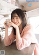 A woman sitting at a table with a cup of coffee.