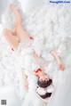 A woman laying on top of a pile of fluffy white clouds.