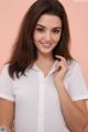 A woman in a white shirt posing for a picture.