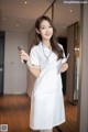 A woman in a white lab coat holding a stethoscope.